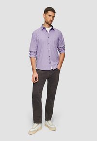 Lichtpaarse geruite shirt met knoopsluiting, opgerolde mouwen, gecombineerd met donkere jeans en witte sneakers. Eenvoudig ontwerp, casual pasvorm.