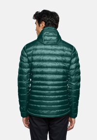 Giubbotto puffa verde con colletto alto, caratterizzato da una trapuntatura orizzontale, una superficie liscia e lucida, e polsini elasticizzati.