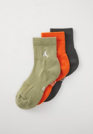 Tre sammenbrettede idrettsokker i olivengrønn, knalloransje og mørkegrå, hver med en hvit Jumpman-logo nær kanten.