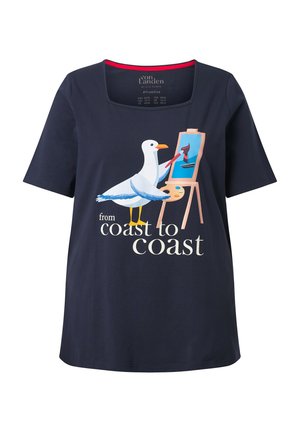 Marineblaues Hemd mit einem Möwenmotiv, die ein Segelboot auf einer Staffelei malt, der Text lautet "von Küste zu Küste."