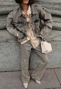 Džinsu jakas ar nolietotu apdari, beigu pogu krekls, rakstainās platas bikses un gaismas krāsas soma. Iekļauti arī kniedēti augstpapēžu apavi.