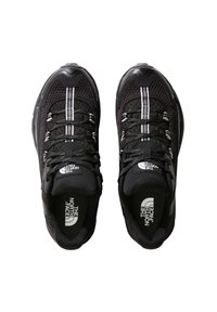 Zapatillas atléticas negras con parte superior de malla, acentos blancos y logotipo. Presentan suelas acolchadas, cierre con cordones y un diseño de punta redonda.