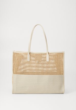 Sac fourre-tout beige avec une partie supérieure en rotin tressé, une section inférieure lisse, des poignées doubles et un détail de logo subtil à l'avant.