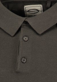 Polo shirt grigio scuro con colletto, tre bottoni neri sul davanti e un'etichetta del marchio tessuta al colletto. Tessuto testurizzato.