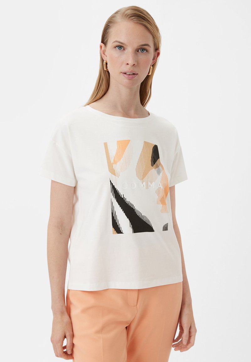 Weißes Baumwoll-T-Shirt mit geometrischem Druck in Pfirsich-, Schwarz- und Beigetönen. Kurze Ärmel und runder Halsausschnitt.