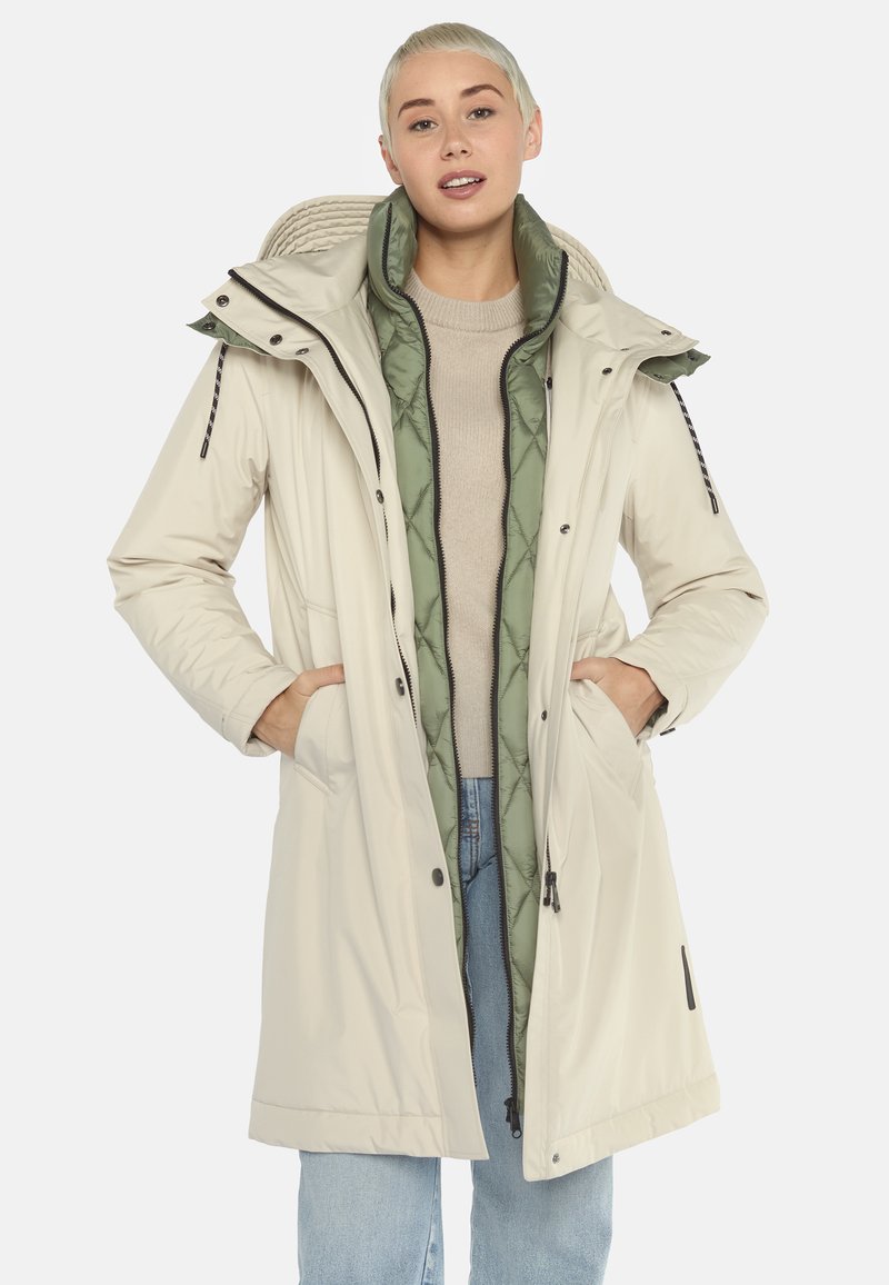 Lichtbeige geïsoleerde jas met een afneembare groene voering, ritssluiting, verstelbare capuchon en zijzakken, ontworpen voor warmte en bedekking.