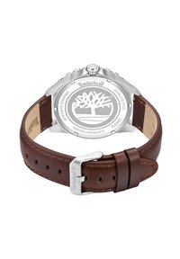 Timberland pulksteņi ar nerūsējošā tērauda korpusu un brūnu ādas siksnu. Aizmugurē ir Timberland logo, un tas ir ūdensizturīgs.