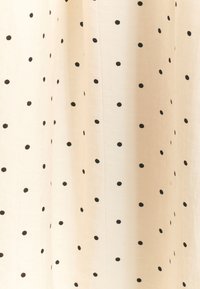 Cremefarbener Stoff mit schwarzen Polka-Dots, leichter Textur, fallende Optik, mit gleichmäßig verteilten kreisförmigen Mustern.