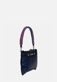 Sac matelassé bleu marine avec une poignée tressée multicolore, équipé de quincaillerie en argent et de deux boutons-pression à l'avant. Texture lisse et brillante.