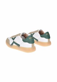Sneakers bianchi con accenti verdi e beige, caratterizzati da un esterno in pelle liscia, punta arrotondata e suola in gomma traslucida. Dettaglio del logo evidente.