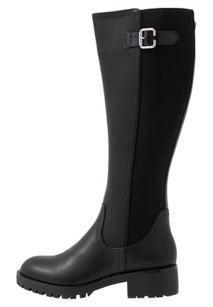 Black leather knee-high boot with a textured, mesh side panel, a rounded toe, and a low heel. Features a buckle accent on the side.