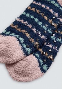 Calcetines de peluche azules y rosas con un patrón a rayas, textura suave y acentos brillantes, punteras redondeadas y botones decorativos.