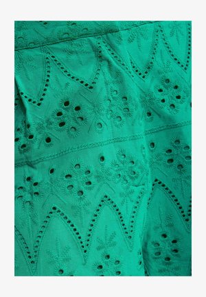 Pávakék szövet, melyen bonyolult virágos hímzés és szemminták szimmetrikusan ismétlődő geometriai alakzatokban rendezve.