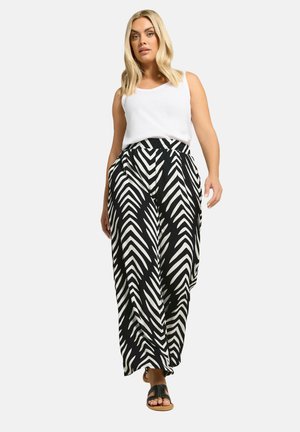 Pantaloni a gamba larga con motivo a zigzag in bianco e nero abbinati a un top bianco, dotati di una fascia in vita comoda e un taglio rilassato.