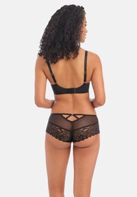 Sort lingeri sæt bestående af en bralette med justerbare stropper og hægte lukning, samt matchende underdel med blonder og netdetaljer.