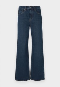 Tumed pesu, laienevad teksad, mis on valmistatud denimist. Omab viit taskut, nööbi sulgemist ja nähtavat õmblust õmblustel.