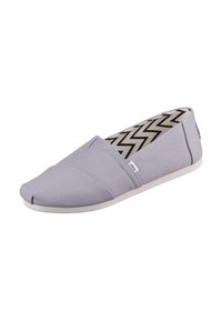 Scarpa slip-on di tessuto grigio chiaro con punta arrotondata, pannelli elastici sui lati e fodera interna con motivo a zigzag. Presenta una suola testurizzata.