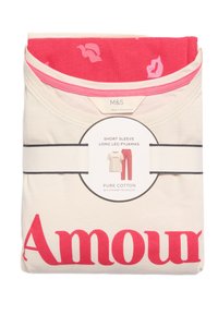 Katoenen pyjama's met korte mouwen en lange benen; crèmekleurig top met "Amour" print, roze onderkant met lippenpatroon, vastgemaakt met een zwarte band.