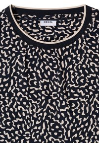 T-shirt noir à col rond avec un motif abstrait beige en forme de zigzags et une bordure noire et beige autour du col, étiqueté "CECIL".