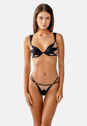 Zwart lingeriesetje met een doorschijnende bh met bloemvormige uitsparingen en verstelbare bandjes, gecombineerd met een bijpassende thong met gouden accenten.