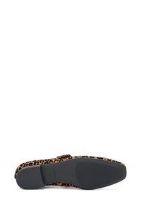 Zapato plano con estampado de leopardo, punta redondeada, parte superior de tela suave, suela de goma negra y correa ajustable para un ajuste seguro.