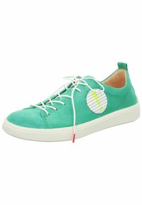 Grüne Wildledersneaker mit weißer Gummisohle, ausgestattet mit weißen Schnürsenkeln und einem runden Patch mit grünem Akzent. Glatte Textur und lässiges Design.