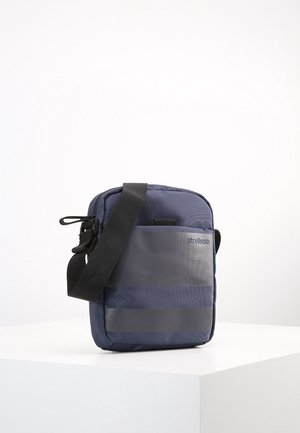 Borsa a tracolla blu navy realizzata in tessuto texturizzato, con pannello frontale grigio, tracolla regolabile e dettaglio del logo. Design leggero e compatto.