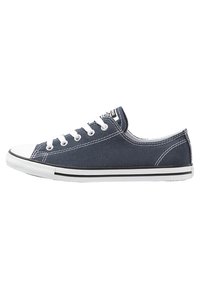 Baskets en toile bleue marine avec semelles en caoutchouc blanc, lacets blancs et couture contrastante. Présente un design basse et des rayures noires.