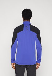 Ilgi piedurkņu sporta krekls, zils un melns, ar augstu apkakli. Iespējas ietver logotipu uz aizmugures, divkrāsu dizainu un gludu, elastīgu audumu.