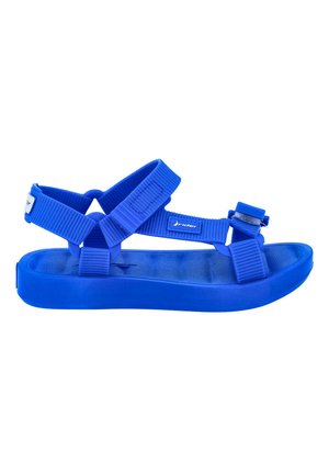 Sandalias azules con suela de goma plana, que cuentan con correas de nailon texturizado ajustables para un ajuste seguro. Diseño sencillo, apto para uso casual.