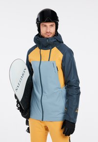 Blauwe en gele skijas met een ritszak, zwarte handschoenen en een witte snowboard, met een gestructureerde stof en een verstelbare capuchon.