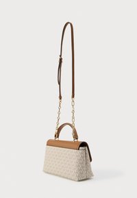 Μπεζ χειροποίητη τσάντα με καφέ δερμάτινο επάνω μέρος, αλυσίδα και ρυθμιζόμενο λουρί, με επαναλαμβανόμενο μοτίβο λογοτύπου στο ύφασμα.