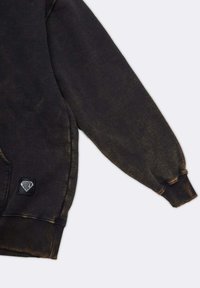 Zwarte hoodie met een gestructureerde afwerking. Heeft een geribde zoom en manchetten, en een klein logo-opgestikt aan de zijkant.