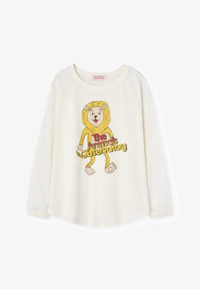 Bijela košulja dugih rukava sa grafikonom crtanog lava sa žutom grivom i šapama. Natpis glasi "The Animals Observatory" u jarkim bojama.