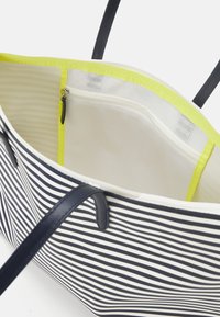 Sac fourre-tout rayé avec des lignes bleu marine et blanches, dotée d'une doublure jaune vif et d'une poche à zip en mesh pour l'organisation.