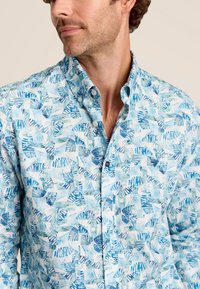 Overhemd met knoopsluiting, voorzien van een blauw-wit tropisch bladdessin, met een zachte stoftextuur en een klassieke kraag.