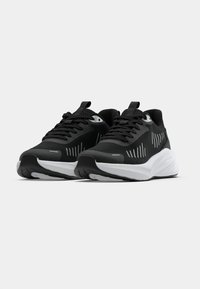 Fekete sportcipő texturált hálós felső résszel, fehér párnázott középtalppal és fekete gumitalppal. Jellemzői a fűzők és a húzófülek.