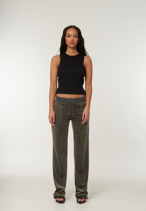 Top corto senza maniche nero con dettagli ricamati abbinato a pantaloni larghi verde oliva con tasche frontali e vita con cordoncino.