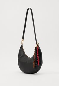 Black leather handbag with a curved shape, featuring a gold zipper and three braided tassels in brown, red, and black for added detail.