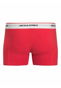Rote Baumwoll-Boxershorts mit einem weißen elastischen Bündchen, das das schwarze "JACK & JONES"-Logo zeigt. Glatte Textur und enganliegendes Design.