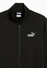 Sort zip-up jakke lavet af glat materiale, med høj krave og et hvidt Puma-logo på venstre bryst. Ingen synlige mønstre eller accenter.