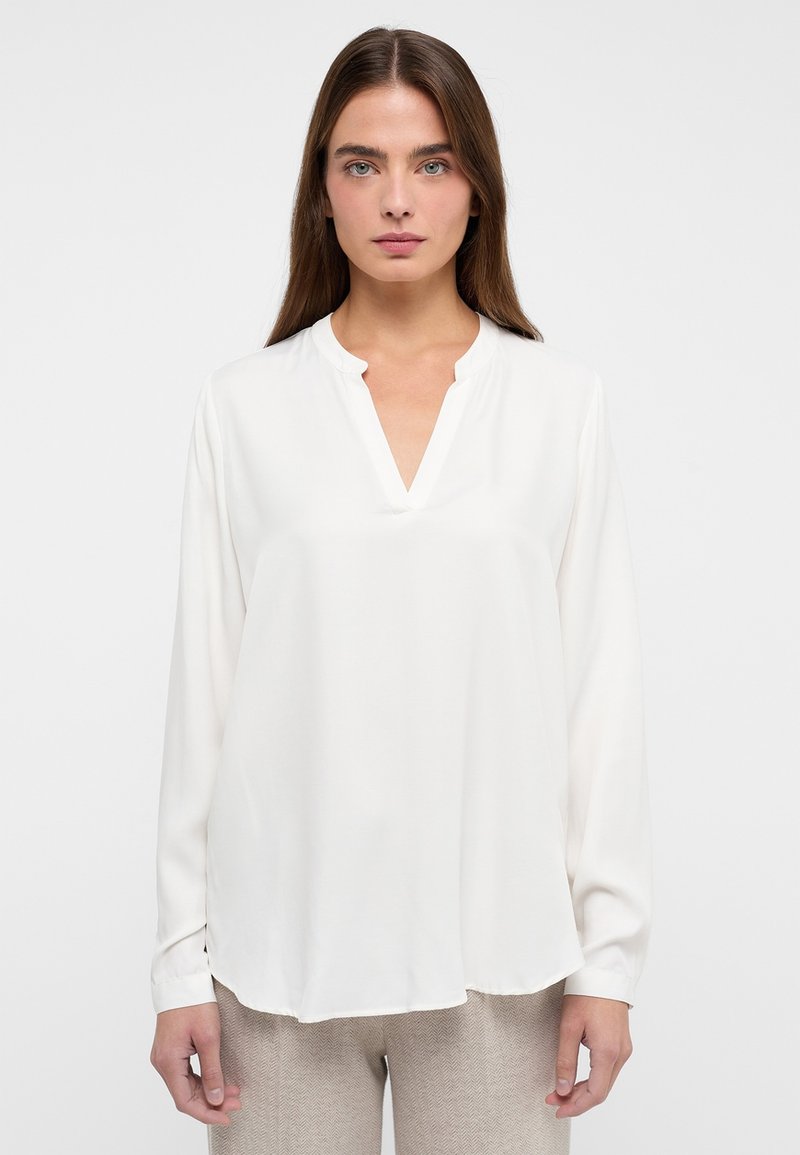 Weiße Bluse mit langen Ärmeln und V-Ausschnitt, aus glattem Stoff; hat einen abgerundeten Saum und subtile Nahtdetails.