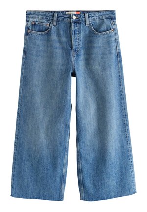 Széles szárú kék farmernadrág elülső zsebekkel, övbújtatókkal, gombos és cipzáras rögzítéssel, a derékrész belsején "CROP WIDE" felirattal.