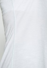 Top in morbido tessuto di un blu chiaro, con una leggera trama, caratterizzato da una vestibilità slim e una cucitura a contrasto lungo la cucitura laterale.