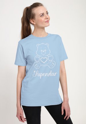 Lys blå bomuld t-shirt med et hvidt bjørne grafisk design og teksten "Superstar" nedenunder, med en afslappet pasform og korte ærmer.