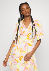 Vestido envolvente com um padrão abstrato multicolorido em rosa, amarelo e laranja. Feito de tecido leve, com mangas curtas e um cinto de laço.