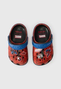 Rde klompe z vzorom pajkove mreže, modrim trakom in različnimi nalepkami v temi Marvel. Narejene so iz lahkega materiala in imajo prezračevalne luknje.