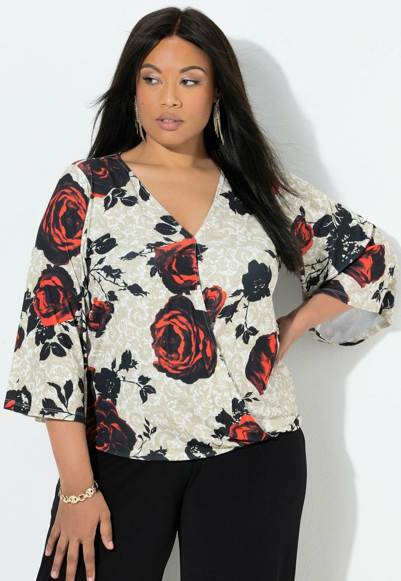 Květinová blůza s výstřihem do V, výraznými červenými a černými růžemi na béžovém pozadí a středními zvonovými rukávy. Hladká textilie.
