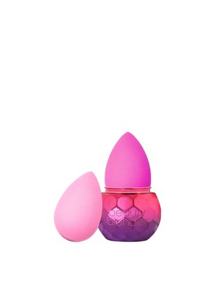 Rosa Make-up-Schwämme in Tropfenform, einer in einem honigwabenförmigen Behälter, der von Pink zu Lila übergeht und einen goldenen Rand hat.