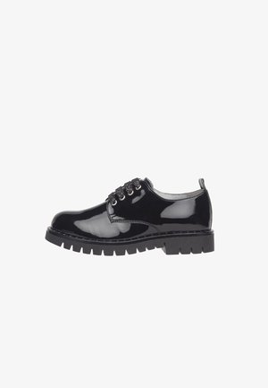 Chaussure à lacets en cuir noir brillant avec semelle épaisse crantée et bout arrondi, vue de côté extérieur sur fond blanc.